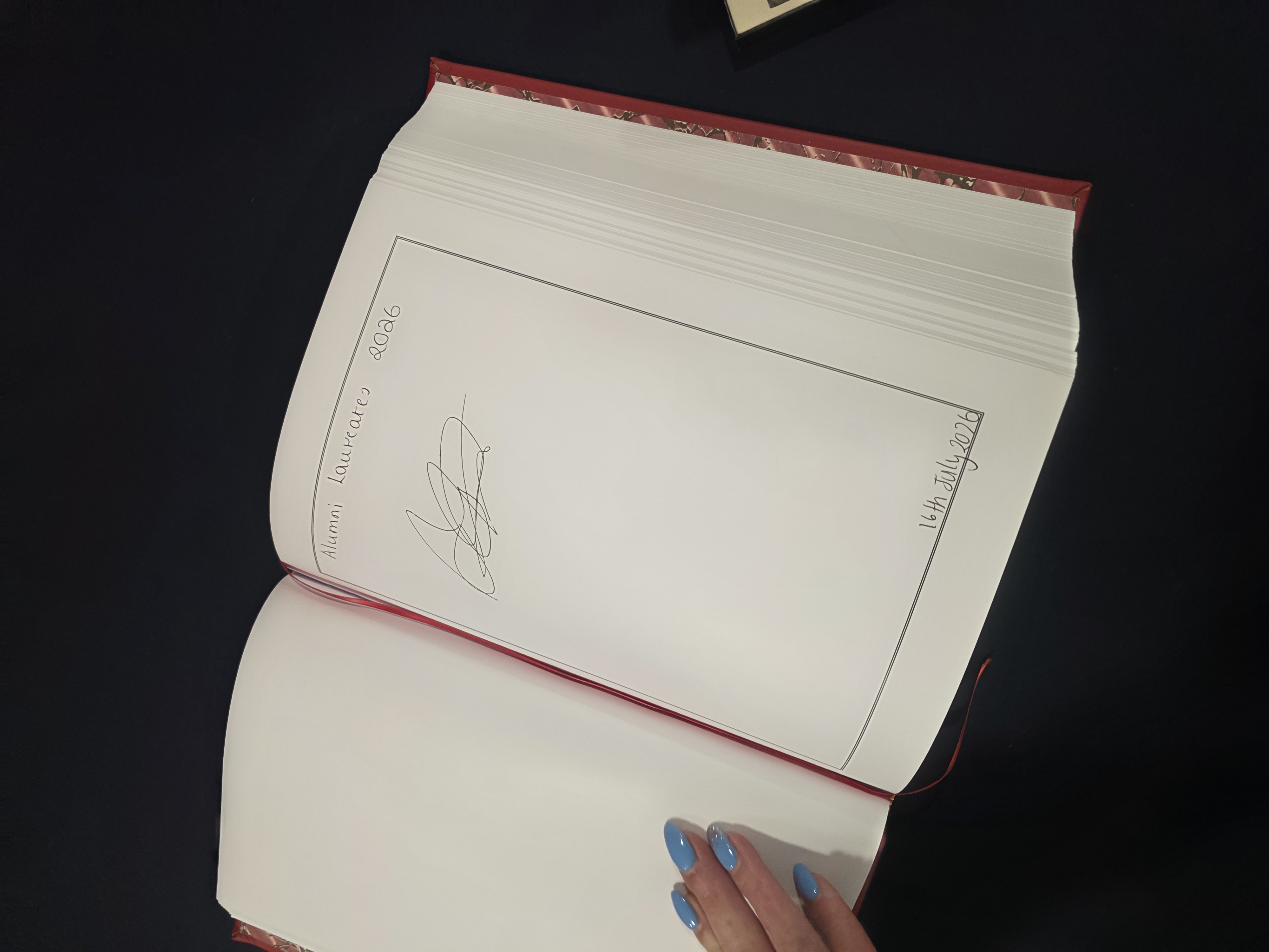 Dr Phininder Balaghan signing the University of Hull book at the laureate ceremony